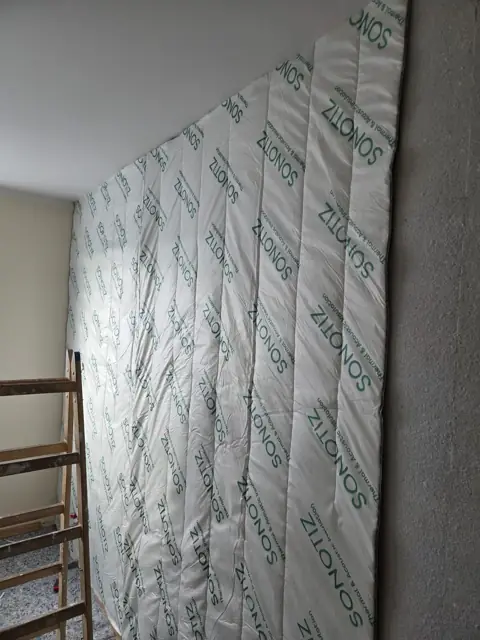 Maty akustyczne na ścianie w trakcie montażu